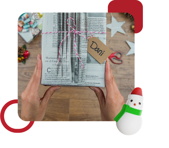 Manos de mujer sosteniendo regalo envuelto en papel periódico con Cinta Súper Adhesiva Scotch®.