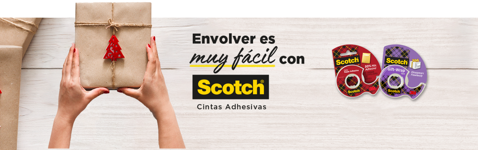 Manos de mujer sosteniendo regalo sobre una mesa que tiene Cinta Súper Adhesiva Scotch® y Cinta de Regalo Scotch.