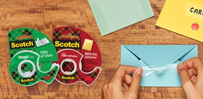 Uso de producto Cintas Adhesivas Scotch® en sobre color azul, packshot Cinta Doble Cara Scotch® y packshot Cinta Mágica Scotch®.
